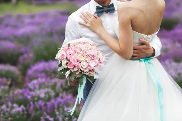 Braut und Bräutigam mit einem Hochzeitsstrauß aus Blumen. — Stockfoto