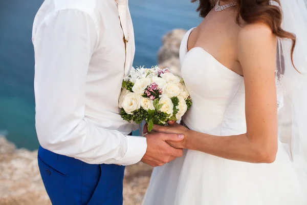 The Bride and groom holding a wedding bouquet of flowers. — Stock Photo, Image