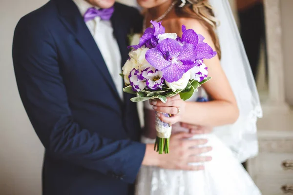 Les mariés tenant un bouquet de fleurs de mariage . — Photo