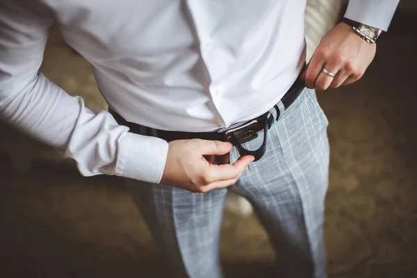 Hombre corrige cinturón, honorarios novio, mans manos, vestirse, hombre botones pantalones, jeans . — Foto de Stock