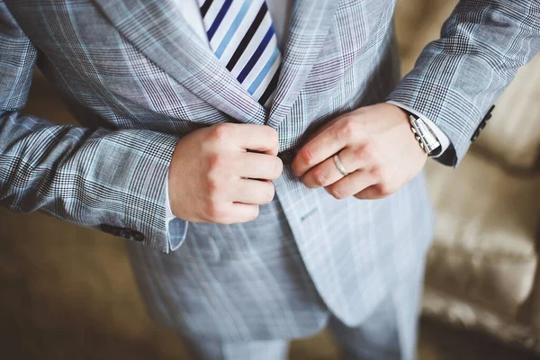 Il giovane sposo nel giorno del matrimonio. sta abbottonando i bottoni sulla giacca . — Foto Stock