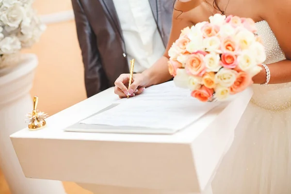 Bride and groom signing marriage wedding certificate at registry. — Stock Photo, Image