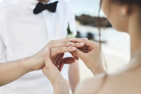 Noivo colocando um anel no dedo noivas durante a cerimônia de casamento . — Fotografia de Stock