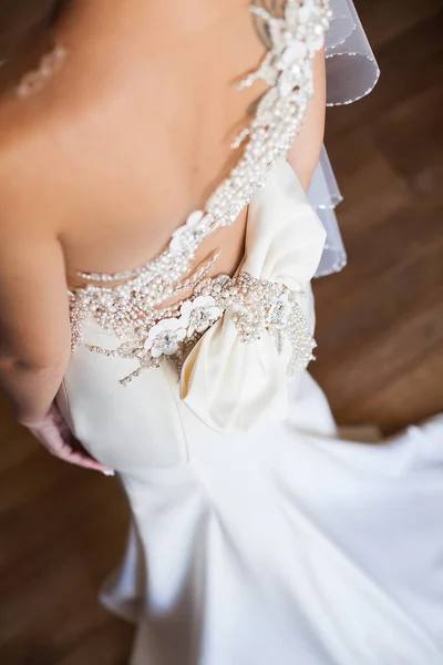 Brautjungfer macht Schleife-Knoten auf dem Rücken der Bräute Brautkleid. — Stockfoto