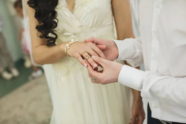 Οι νιόπαντροι ανταλλάσσουν δαχτυλίδια, ο γαμπρός βάζει το δαχτυλίδι στο χέρι της νύφης στο ληξιαρχείο γάμου.. — Φωτογραφία Αρχείου
