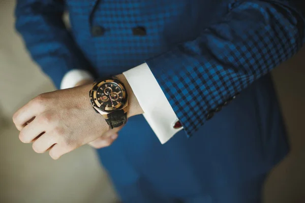 Un uomo d'affari vestito di blu controlla il tempo con il suo orologio  . — Foto Stock
