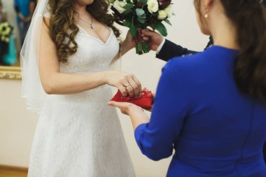 Yeni evliler yüzükleri takar, damat da nikah dairesinde yüzüğü gelinliğe takar..