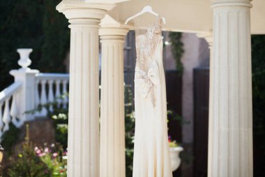 Sokakta asılı duran beyaz gelinlik. Gelinin ücretleri.