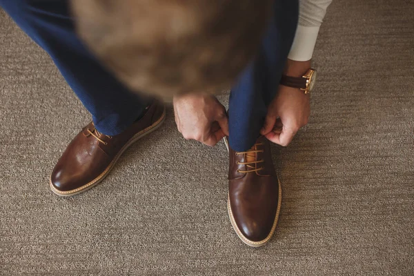 Le mani di Mans legano il lacci delle sue scarpe nuove. Concetto di uomo, business, moda e calzature - primo piano dei lacci uomo-gamba e mani . — Foto Stock