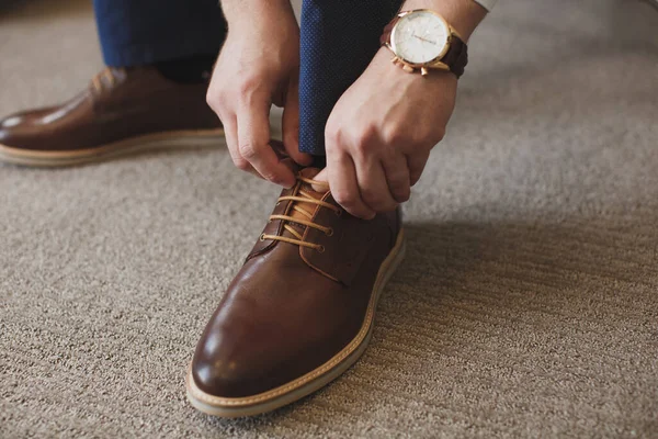 Le mani di Mans legano il lacci delle sue scarpe nuove. Concetto di uomo, business, moda e calzature - primo piano dei lacci uomo-gamba e mani . — Foto Stock