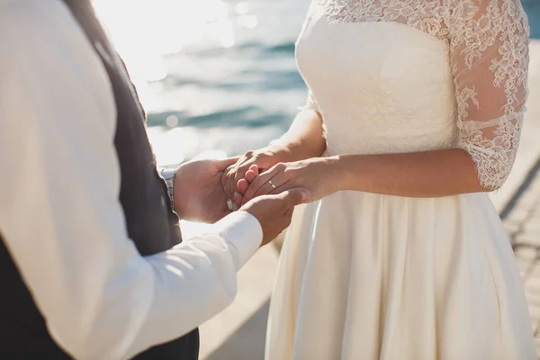 Bruid en bruidegom die samen lopen en hun handen vasthouden. Berg. Zee. Oceaan. — Stockfoto