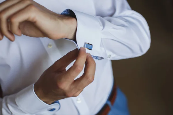 Крупним планом рука чоловіка, як носить білу сорочку і манжету . — стокове фото