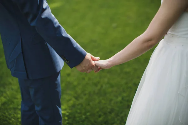 Braut und Bräutigam gehen Hand in Hand. — Stockfoto