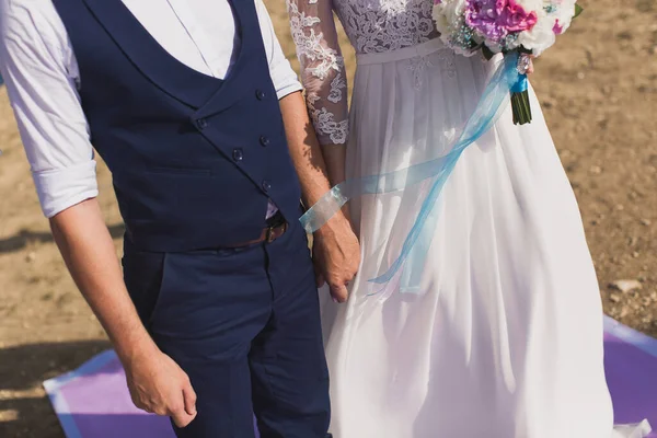 Mariée et marié lors d'une cérémonie de mariage tenant la main . — Photo