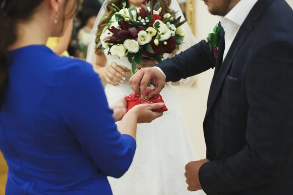 Nowożeńcy wymieniają pierścionki, pan młody wkłada obrączkę na ręce panny młodej w urzędzie stanu cywilnego.. — Zdjęcie stockowe