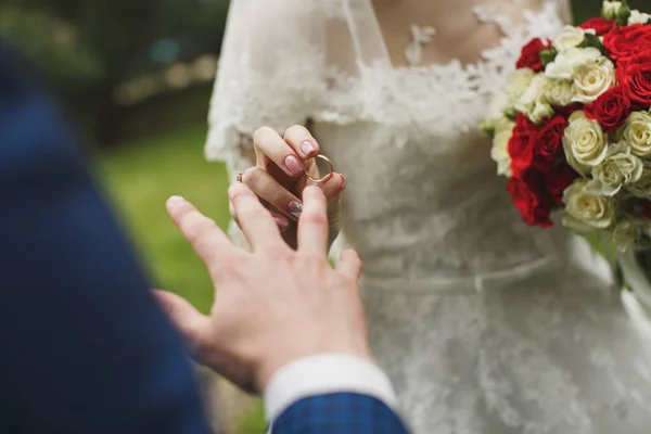 新娘和新郎把结婚戒指戴在手上. — 图库照片