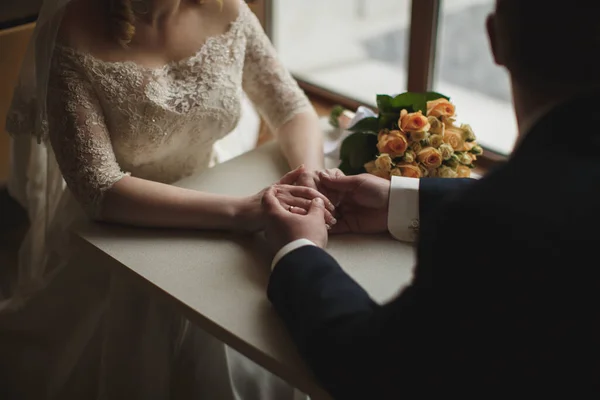 Невеста и жених держатся за руки в ресторане . — стоковое фото