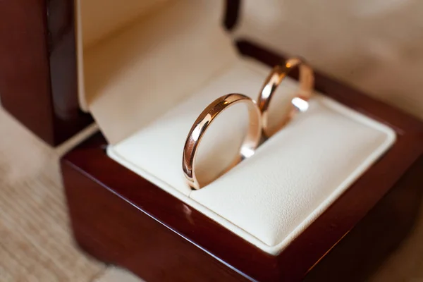 Gouden bruiloft ringen in een houten doos. — Stockfoto