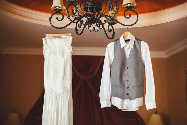 Svatební šaty nevěsty a ženicha oblek. Hotel. Lustr. Visí. — Stock fotografie
