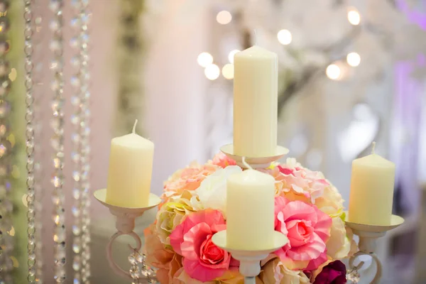 लग्नात मेणबत्त्या आणि गुलाबी फुलांसह मेणबत्ती धारक . — स्टॉक फोटो, इमेज