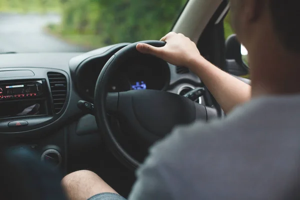 De man achter het stuur van een auto. Handen dicht.. — Stockfoto