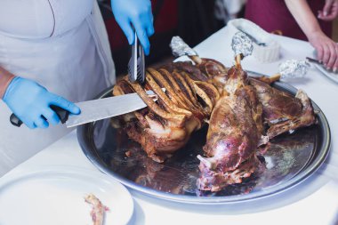 Şef restoranda bir kuzuyu sunar ve muayene eder..
