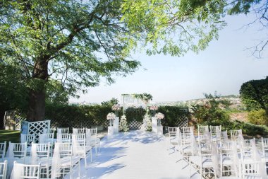 Mavi gökyüzüne karşı parkta güzel bir düğün töreni..