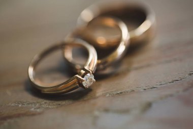 Ahşap arka plan üzerinde üç alyans.