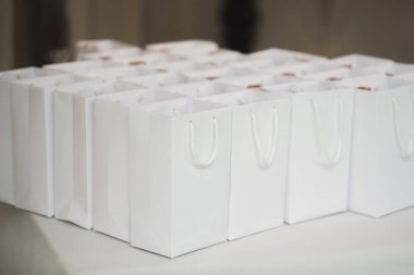 Düğünde misafirler için beyaz karton bir pakette hediyeler..