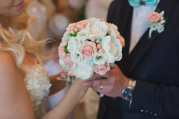 Жених в костюме дарит невесте белый и персиковый свадебный букет . — стоковое фото