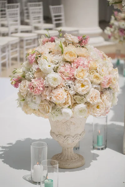 Bellissimo mazzo di rose in un vaso su uno sfondo di un arco nuziale. Bella allestita per la cerimonia nuziale . — Foto Stock