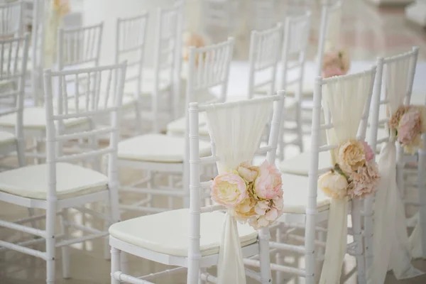 Hochzeitsdekoration Blumen auf Stühlen. Hochzeitsanmeldung, weiße Stühle für die Hochzeit dekoriert. Detail der Hochzeitsvorbereitung. — Stockfoto