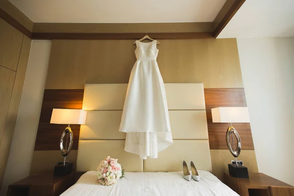 Beautiful wedding dress on hanger in room. — Stock Photo, Image