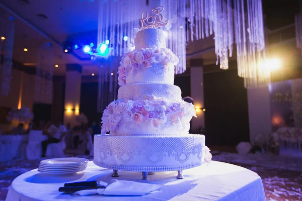 Большой белый свадебный торт с розовыми розами на белом столе . — стоковое фото