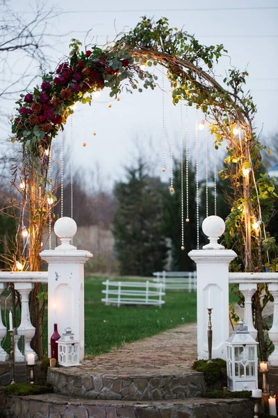 Wedding arch with beads, lights and candles. — Stock Photo, Image