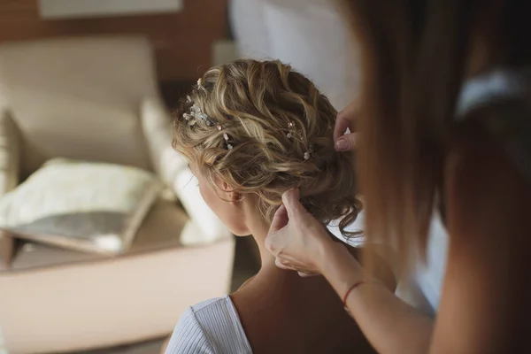 De stylist maakt een elegante kapsel voor de bruid. — Stockfoto