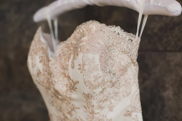 Luxusní svatební šaty visí na ramínku. — Stock fotografie