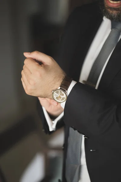 Los hombres miran a mano. Un hombre con un traje negro . — Foto de Stock