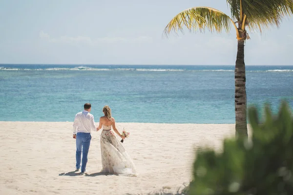 Noiva e noivo estão indo em direção ao oceano . — Fotografia de Stock