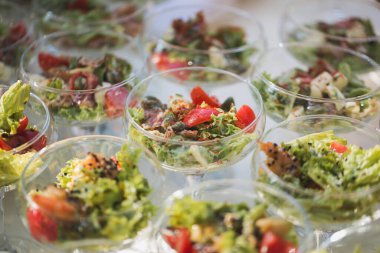 Düğünde resepsiyon. Cam bir masada abur cubur ve şarap bardakları.