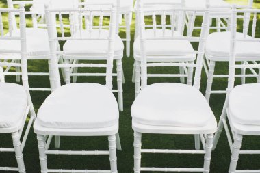 Parktaki törende güzel beyaz düğün sandalyeleri.
