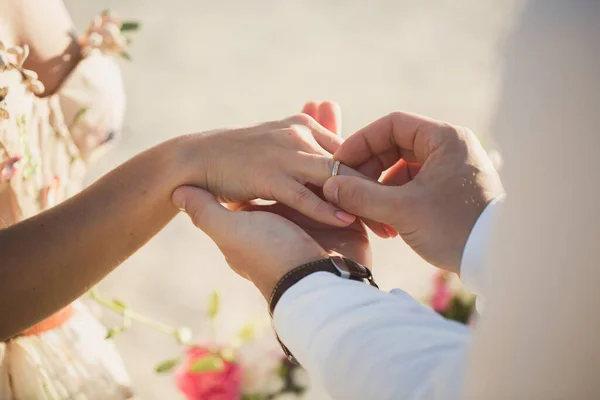 De bruidegom draagt ring om de vinger van de bruid. — Stockfoto
