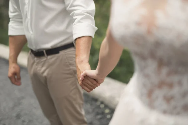 Bräutigam hält Braut die Hand und geht — Stockfoto