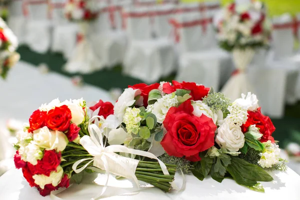 Cerimonia di matrimonio all'aperto. Bouquet con fiori rossi . — Foto Stock