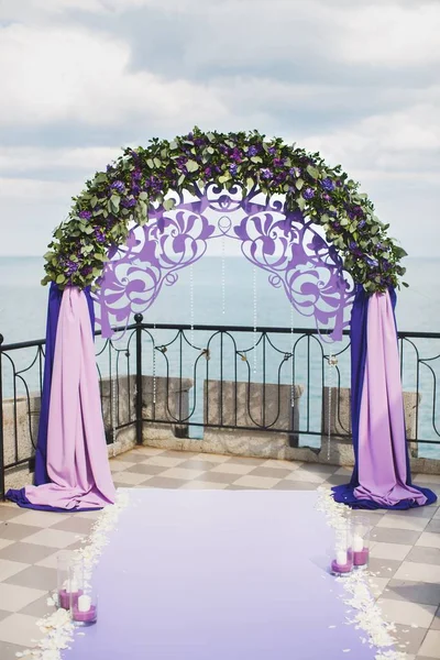 Wedding arch of purple color on the background of the sea. — Stock Photo, Image