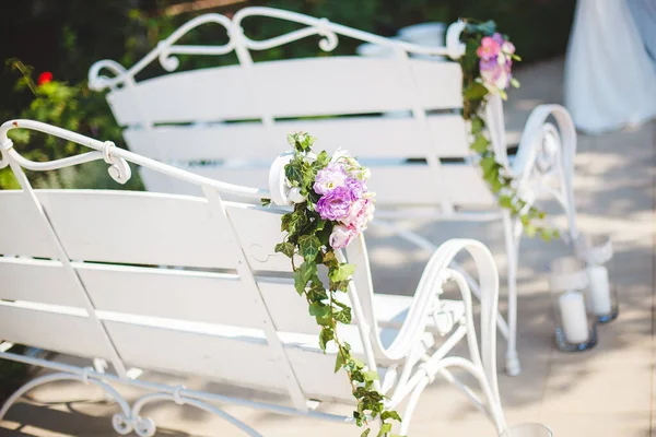 Weiße Bank mit Blumen bei der Trauung. — Stockfoto