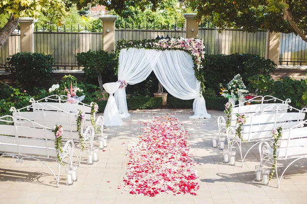Wedding ceremony outdoors. Wedding arch in white with fresh flowers. — Stock Photo, Image