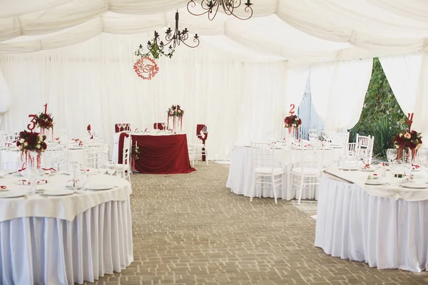 Belo salão de banquetes abaixo de uma tenda de uma recepção de casamento . — Fotografia de Stock