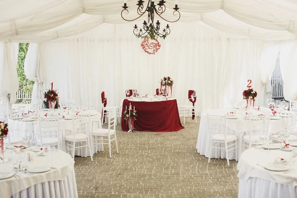 Belo salão de banquetes abaixo de uma tenda de uma recepção de casamento . — Fotografia de Stock