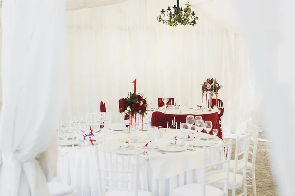 Belo salão de banquetes abaixo de uma tenda de uma recepção de casamento . — Fotografia de Stock